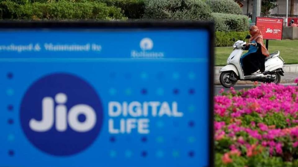 A woman rides her scooter past advertisements of Reliance Industries' Jio telecoms unit, in Ahmedabad, July 5, 2018. REUTERS/Amit Dave/Files