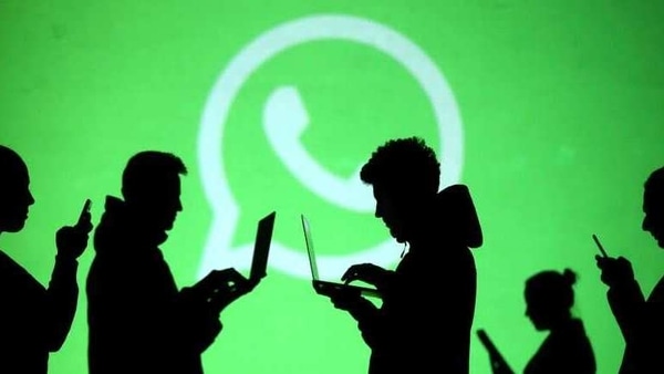 FILE PHOTO: Silhouettes of laptop and mobile device users are seen next to a screen projection of Whatsapp logo in this picture illustration taken March 28, 2018.  REUTERS/Dado Ruvic/Illustration/File Photo