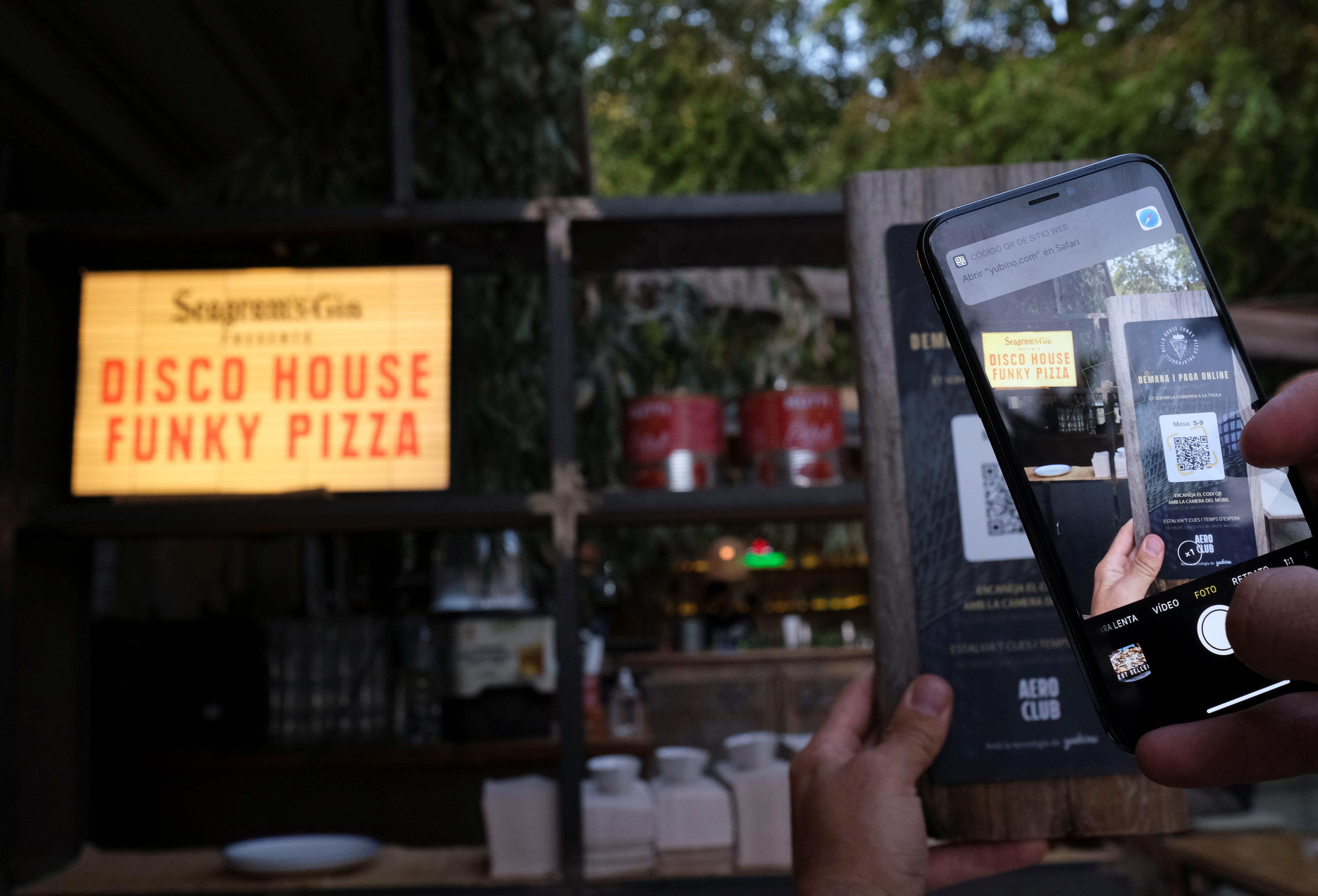 A client using his mobile phone scans the QR code to place an order of a pizza with its ingredientes through of the 