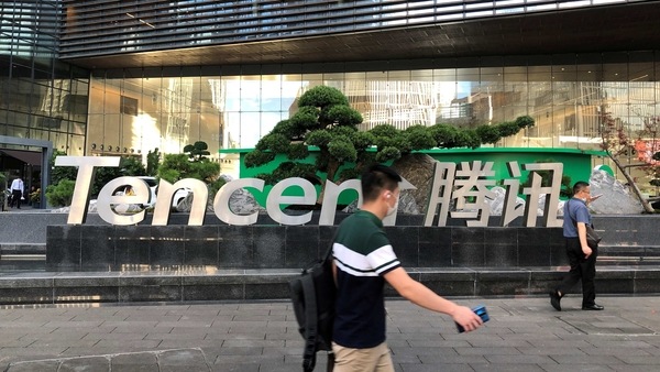 People walk past a Tencent sign at the company headquarters in Shenzhen, Guangdong province, China, August 7, 2020. 