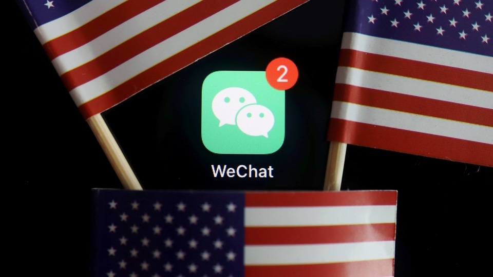 FILE PHOTO: The messenger app WeChat is seen among U.S. flags in this illustration picture taken Aug. 7, 2020. REUTERS/Florence Lo/Illustration/File Photo