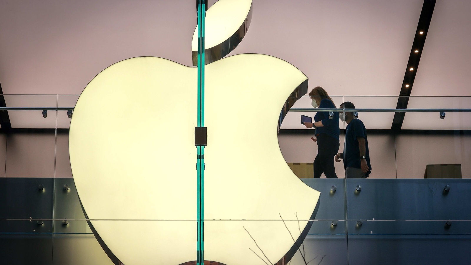 Employees wear protective masks as they walk past signage displayed in the window of the Apple Inc. flagship store in Sydney, Australia, on Friday, Sept. 18, 2020. Employees wear protective masks as they walk past signage displayed in the window of the Apple Inc. flagship store in Sydney, Australia, on Friday, Sept. 18, 2020.