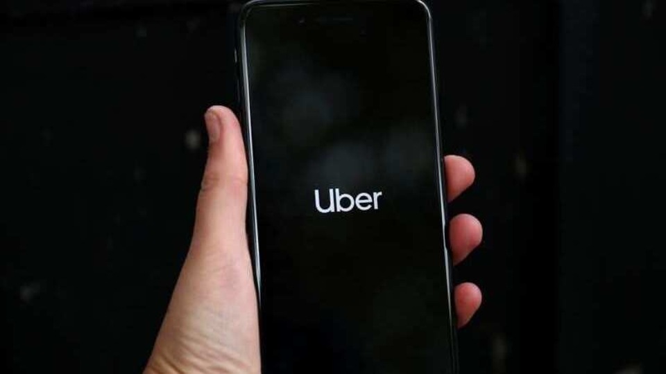 Uber's logo is displayed on a mobile phone in London, Britain.