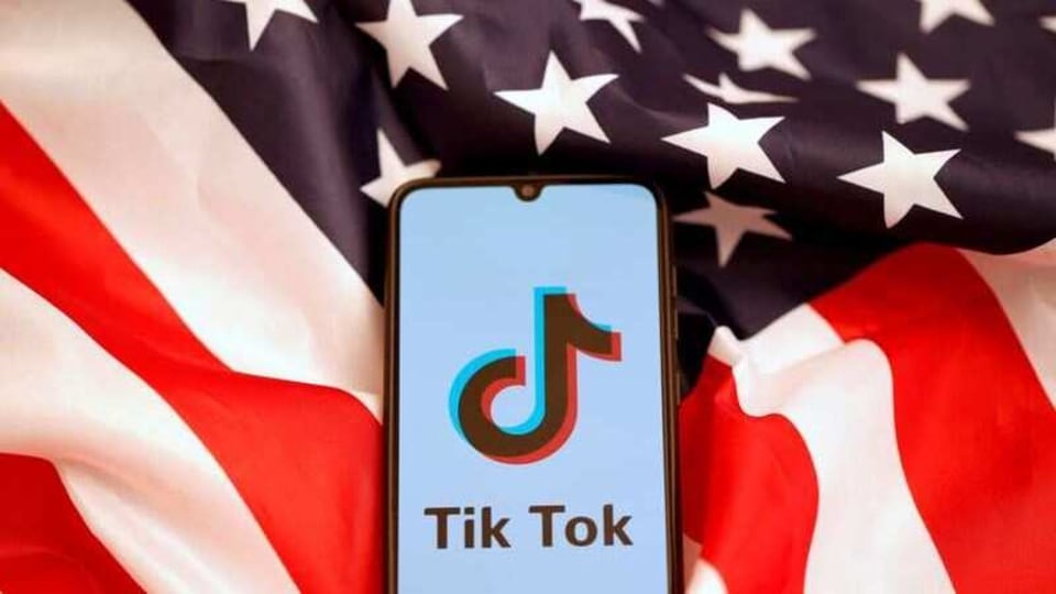 TikTok's logo is displayed on the smartphone while standing on the U.S. flag in this illustration picture taken, November 8, 2019. REUTERS/Dado Ruvic/File Photo