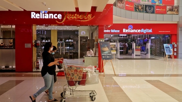 A customer wearing protective mask pushes a trolley with grocery items past Reliance Jewels and Reliance Digital stores of Reliance Industries Ltd, in Mumbai, India, October 7, 2020. REUTERS/Niharika Kulkarni