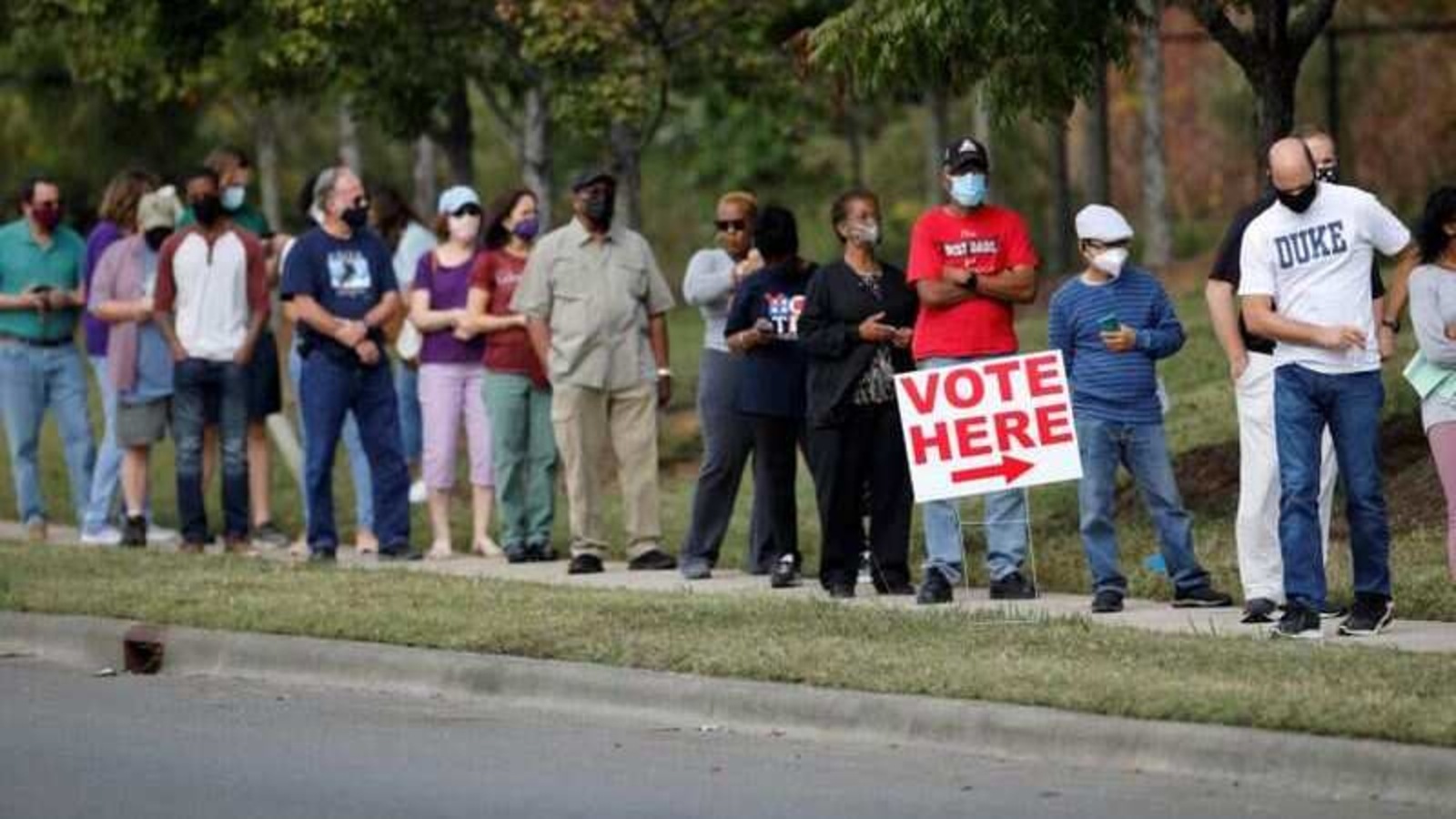 Voters wait in line to enter a polling place and cast their ballots on the first day of the state's in-person early voting for the general elections in Durham, North Carolina, US October 15, 2020.