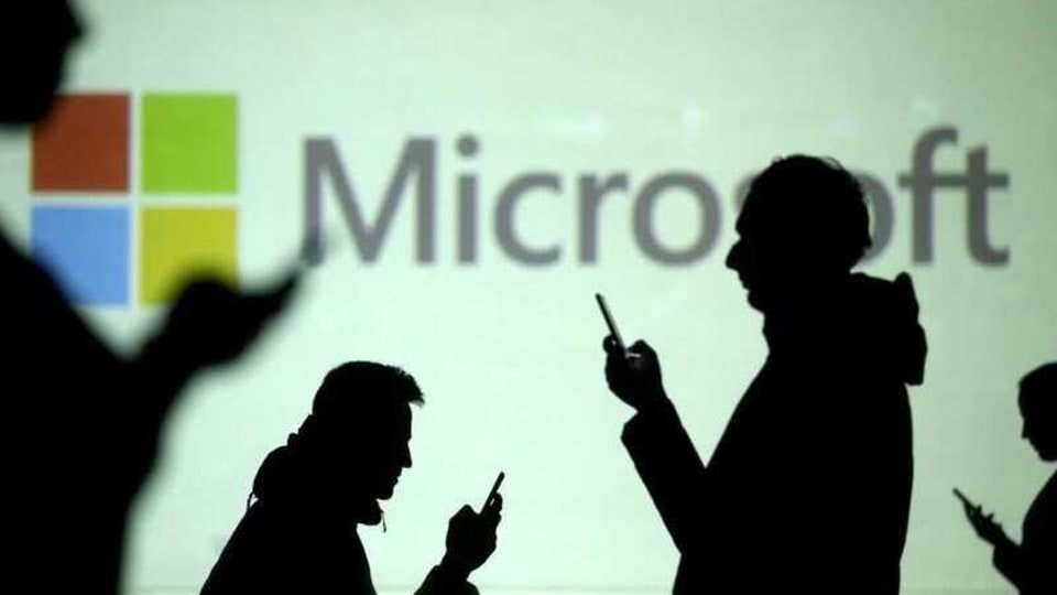 FILE PHOTO: Silhouettes of mobile users are seen next to a screen projection of Microsoft logo in this picture illustration taken March 28, 2018.  REUTERS/Dado Ruvic/Illustration/File Photo/File Photo