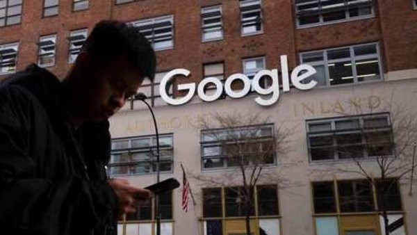 FILE - In this file photo dated Monday, Dec. 17, 2018, a man using a mobile phone walks past Google offices in New York. Monopoly or not, small business owners’ biggest complaint about Google is that its advertising policies favor companies with big marketing budgets. (AP Photo/Mark Lennihan, File)