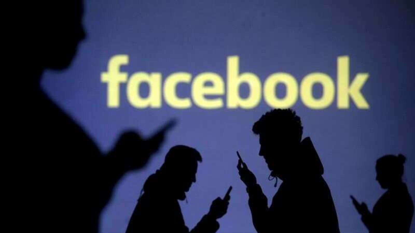 FILE PHOTO: Silhouettes of mobile users are seen next to a screen projection of Facebook logo in this picture illustration taken March 28, 2018.  REUTERS/Dado Ruvic/File Photo