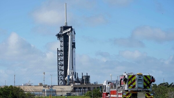 NASA firefighters drive on the road outside the fence near a SpaceX Falcon 9 rocket, with the company's Crew Dragon capsule attached, sits on the launch pad at Launch Complex 39A Friday, Nov. 13, 2020, at the Kennedy Space Center in Cape Canaveral. 