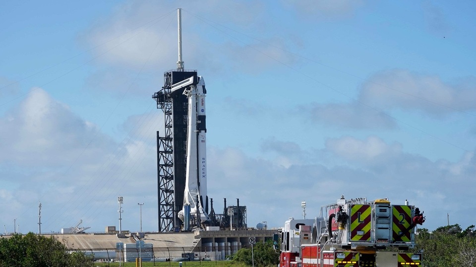 NASA firefighters drive on the road outside the fence near a SpaceX Falcon 9 rocket, with the company's Crew Dragon capsule attached, sits on the launch pad at Launch Complex 39A Friday, Nov. 13, 2020, at the Kennedy Space Center in Cape Canaveral. 