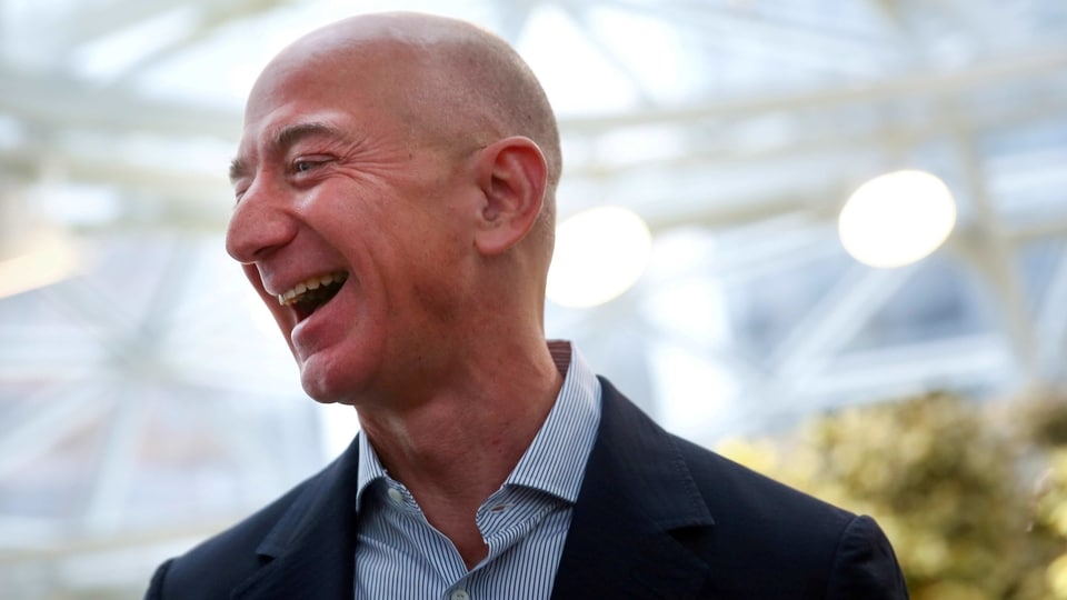 FILE PHOTO: Amazon founder and CEO Jeff Bezos laughs as he talks to the media while touring the new Amazon Spheres during the grand opening at Amazon's Seattle headquarters in Seattle, Washington, U.S., January 29, 2018.   REUTERS/Lindsey Wasson/File Photo