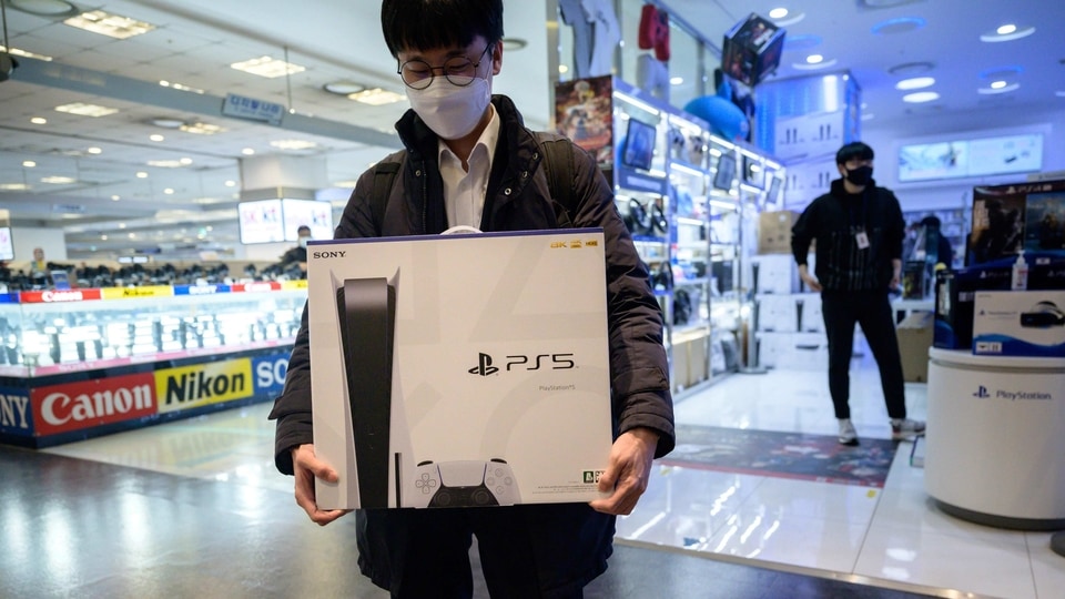In a photo taken on November 12, 2020, a customer walks away after purchasing the new Sony Playstation PS5 in Seoul after Sony launched the new console in select markets around the world. 