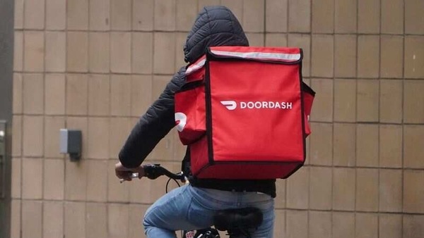 A delivery person for Doordash rides his bike in the rain during the coronavirus disease (COVID-19) pandemic in the Manhattan borough of New York City, New York, U.S., November 13, 2020. REUTERS/Carlo Allegri/Files
