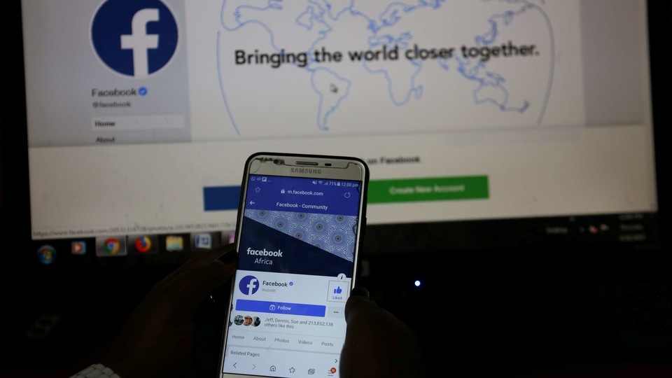FILE PHOTO: An illustration photo shows the Facebook page displayed on a mobile phone internet browser held in front of a computer screen at a cyber-cafe in downtown Nairobi, Kenya April 18, 2019. REUTERS/Stringer/File Photo