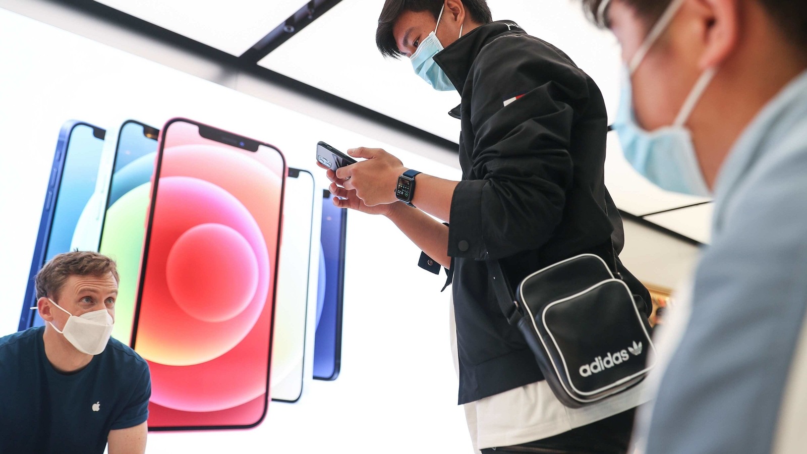A customer wearing a protective mask tries out an Apple Inc. iPhone 12 Pro Max at the Apple flagship store during a product launch event in Sydney, Australia, on Friday, Nov. 13, 2020. Sales of the iPhone fell 21% on anticipation of the new models, which arrived later than usual this year. Cook said the response to the 5G iPhone lineup and other new devices has been A customer wearing a protective mask tries out an Apple Inc. iPhone 12 Pro Max at the Apple flagship store during a product launch event in Sydney, Australia, on Friday, Nov. 13, 2020. Sales of the iPhone fell 21% on anticipation of the new models, which arrived later than usual this year. Cook said the response to the 5G iPhone lineup and other new devices has been