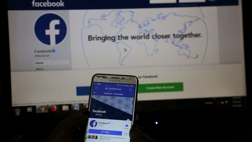 FILE PHOTO: An illustration photo shows the Facebook page displayed on a mobile phone internet browser held in front of a computer screen at a cyber-cafe in downtown Nairobi, Kenya April 18, 2019. REUTERS/Stringer/File Photo