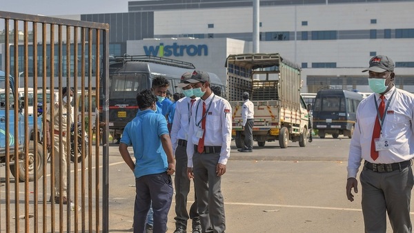 Bengaluru: Security personnel stand guard outside Wistron Infocomm Manufacturing India Pvt Ltd, where a section of workers went on a rampage at its facility manufacturing Apple iPhones and other products  over non-payment of promised wage, at Narasapura area in Bengaluru, Sunday, Dec. 13, 2020. (PTI Photo)(PTI15-12-2020_000116B)