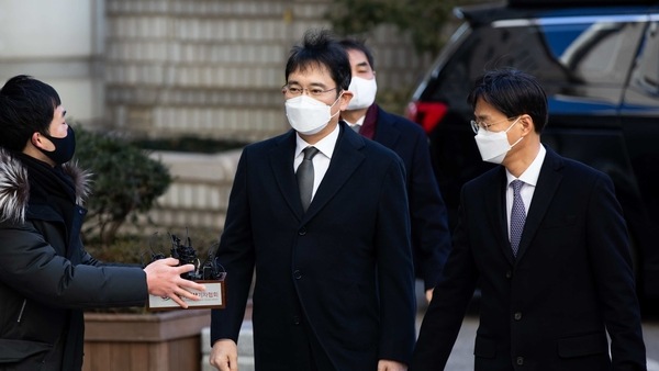 Jay Y. Lee, co-vice chairman of Samsung Electronics Co., center, wears a protective mask as he arrives at the Seoul Central District Court in Seoul, South Korea, on Wednesday, Dec. 30, 2020. Lee faces the possibility of returning to jail if he is convicted.�Photographer: SeongJoon Cho/Bloomberg