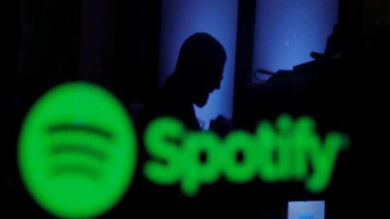 FILE PHOTO: A trader is reflected in a computer screen displaying the Spotify brand before the company begins selling as a direct listing on the floor of the New York Stock Exchange in New York, U.S., April 3, 2018.  REUTERS/Lucas Jackson/File Photo