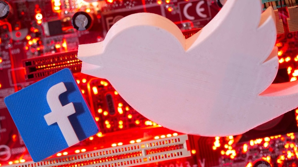 3D printed Facebook and Twitter logos are placed on a computer motherboard in this illustration taken January 21, 2021. REUTERS/Dado Ruvic/Illustration