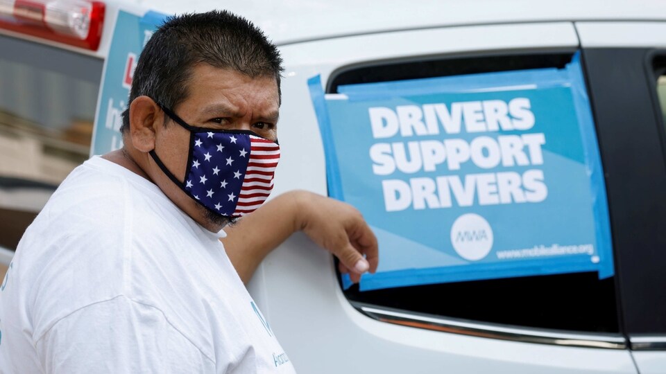 Rideshare driver Jesus Jacobo Zepeda of Lancaster, California takes part in a rally as part of a statewide day of action to demand that ride-hailing companies Uber and Lyft follow California law and grant drivers 