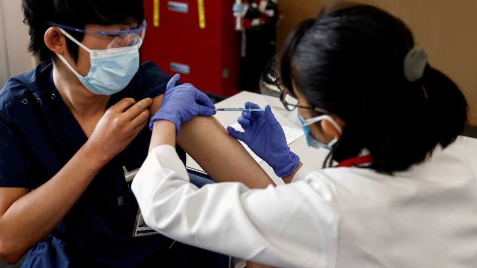 A medical worker receives a dose of the coronavirus disease (COVID-19) vaccine as Japan launches its inoculation campaign, at Tokyo Medical Center in Tokyo, Japan.