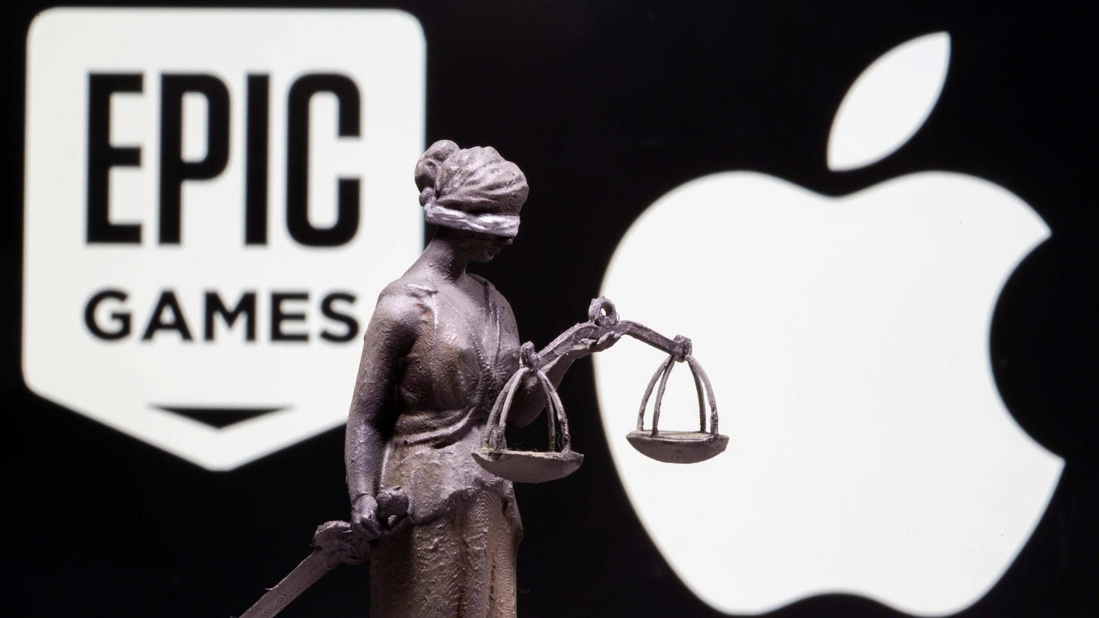 3D printed Lady Justice figure is seen in front of displayed Apple and Epic Games logos in this illustration photo taken February 17, 2021. REUTERS/Dado Ruvic/Illustration