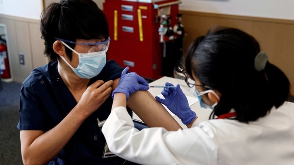 A medical worker receives a dose of the coronavirus disease (COVID-19) vaccine as Japan launches its inoculation campaign, at Tokyo Medical Center in Tokyo, 
