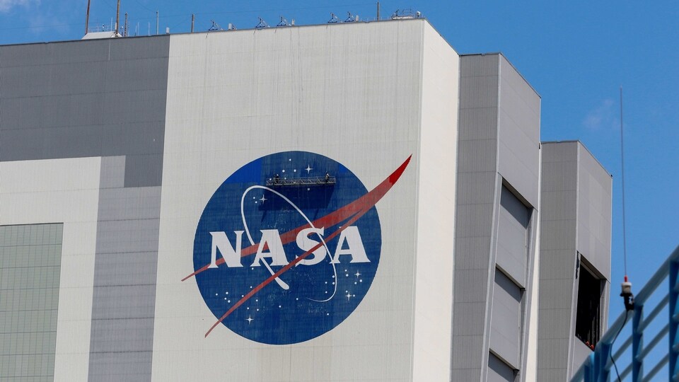 Workers pressure wash the logo of NASA on the Vehicle Assembly Building at the Kennedy Space Center in Cape Canaveral, Florida, US. 