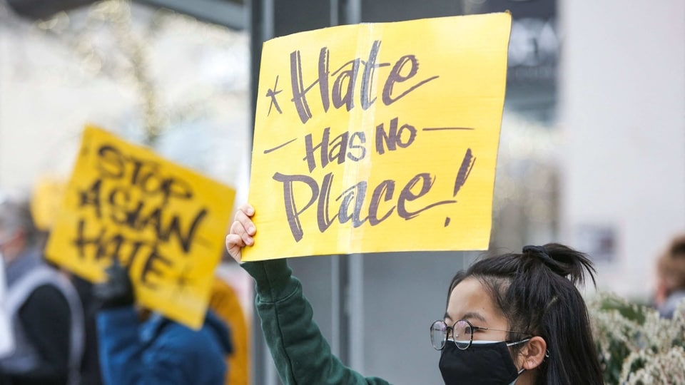 A University of Washington student, who wished to remain anonymous, holds a sign that reads 