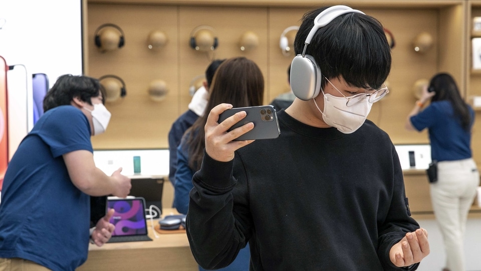 A customer tries on a pair of Apple Inc. AirPods Max headphones at the company's Yeouido store during its opening in Seoul, South Korea, on Friday, Feb. 26, 2021.