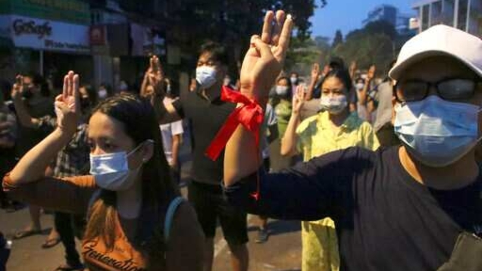 Anti-coup protesters flash three-fingered gesture, a symbol of resistance, during a rally outside their homes in downtown Yangon, Myanmar, Monday morning, March 22, 2021.