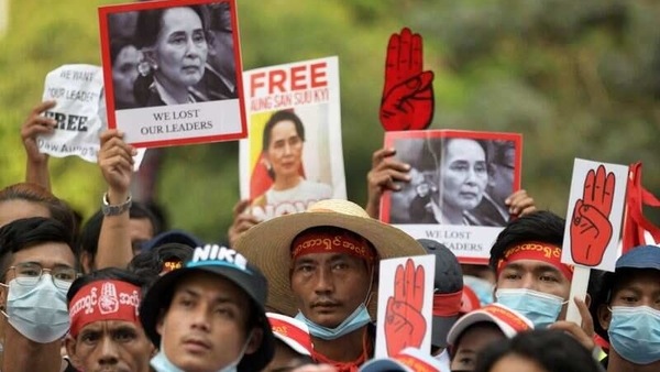 Demonstrators hold placards with pictures of Aung San Suu Kyi as they protest against the military coup in Yangon, Myanmar, February 22, 2021. 