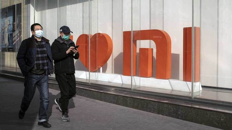 FILE PHOTO: Pedestrians walk past a Xiaomi Corp. flagship store in Shanghai, China.