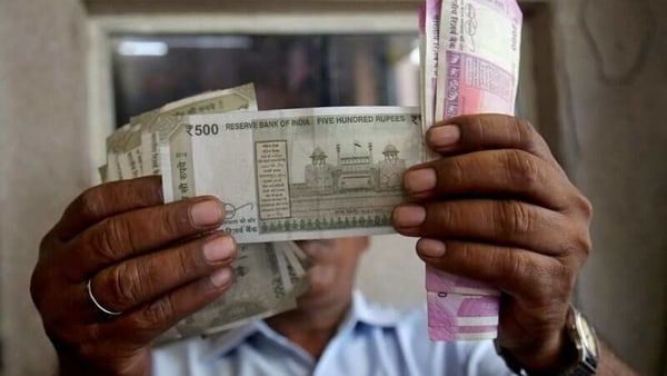 FILE PHOTO: A cashier checks Indian rupee notes inside a room at a fuel station in Ahmedabad, India, September 20, 2018. 