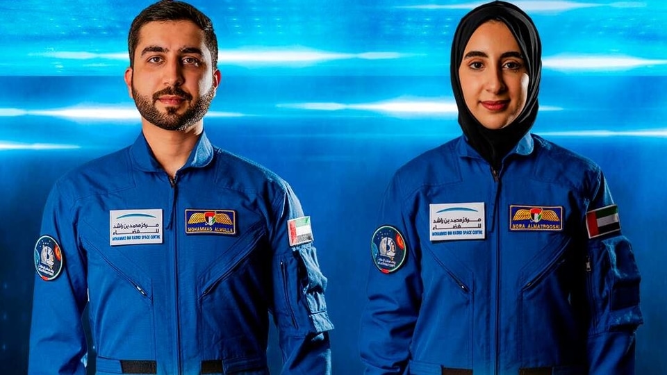 In this undated handout photograph from the United Arab Emirates' state-run WAM news agency, newly named Emirati astronauts Mohammed al-Mulla, left, and Noura al-Matroushi, right, pose for a photo. The United Arab Emirates named the next two astronauts in its space program Saturday, April 10, 2021, including the country's first female astronaut. (WAM via AP)