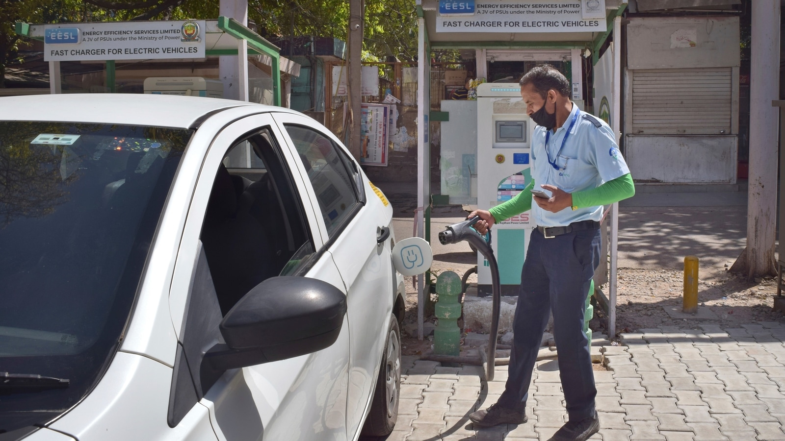 A driver of an electric car charges his vehicle at public charging station in New Delhi, India, Thursday, April 1, 2021. India has ambitions to expand use of electric vehicles to wean itself from polluting fossil fuels, but EVs are still a rarity on its congested highways. A lack of charging stations and poor quality batteries are discouraging drivers from switching over. (AP Photo/Neha Mehrotra)