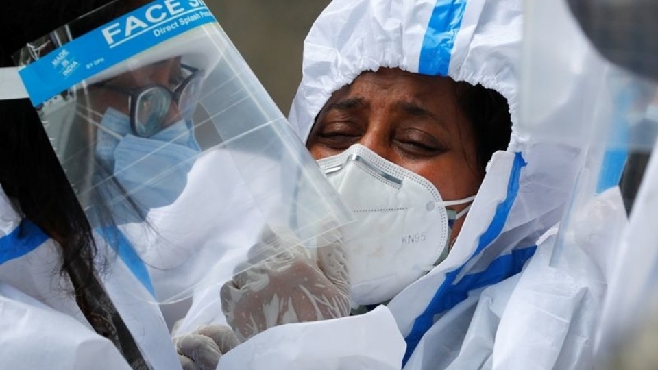 FILE PHOTO: Relatives wearing personal protective equipment (PPE) mourn a man, who died from the coronavirus disease (COVID-19), during his funeral at a crematorium in New Delhi, India April 21, 2021. 