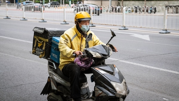 A food delivery courier for Meituan rides a motorcycle in Beijing, China, on Wednesday, April 21, 2021.