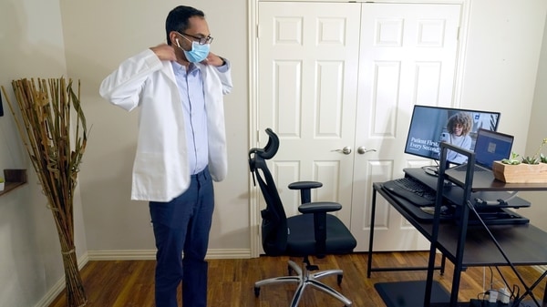 Medical director of Doctor on Demand Dr. Vibin Roy prepares to conduct an online visit with a patient from his work station at home, Friday, April 23, 2021,