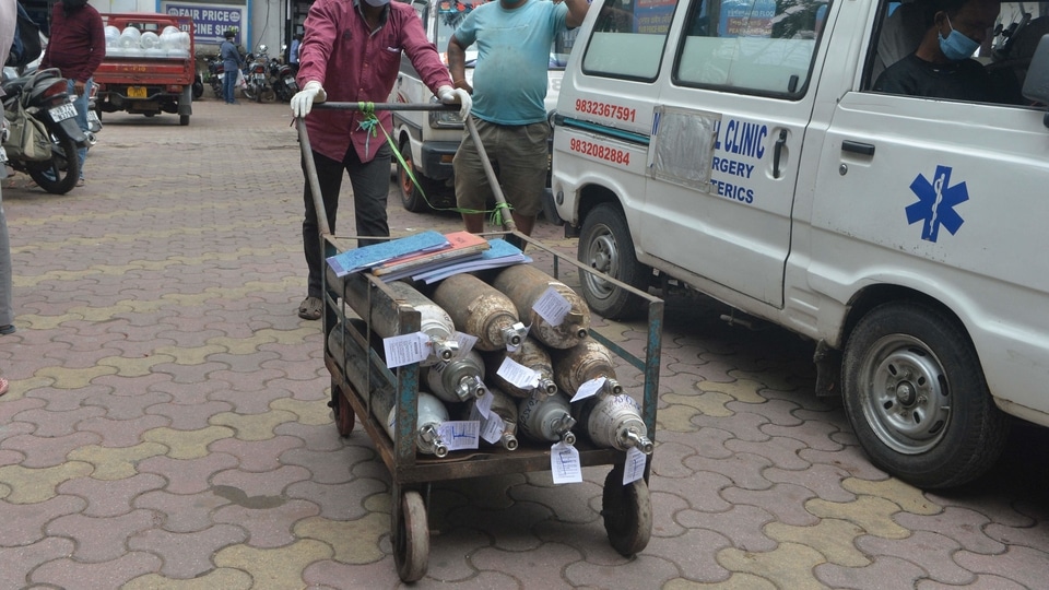 A health worker pushes a trolly loaded with oxygen cylinders outside Siliguri district hospital in Siliguri on May 4, 2021. (Photo by DIPTENDU DUTTA / AFP)