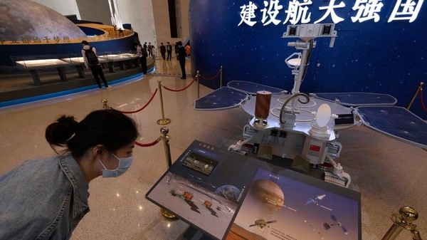 A visitor to an exhibition on China's space program looks at a life size model of the Chinese Mars rover Zhurong, named after the Chinese god of fire, at the National Museum in Beijing on Thursday, May 6, 2021. China has landed a spacecraft on Mars for the first time in the latest advance for its space program. The official Xinhua News Agency said Saturday, May 15, that the lander had touched down, citing the China National Space Administration. 