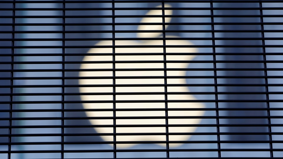 FILE PHOTO: The Apple logo is seen through a security fence erected around the Apple Fifth Avenue store as votes continue to be counted following the 2020 U.S. presidential election, in Manhattan, New York City, U.S., November 5, 2020. REUTERS/Andrew Kelly/File Photo