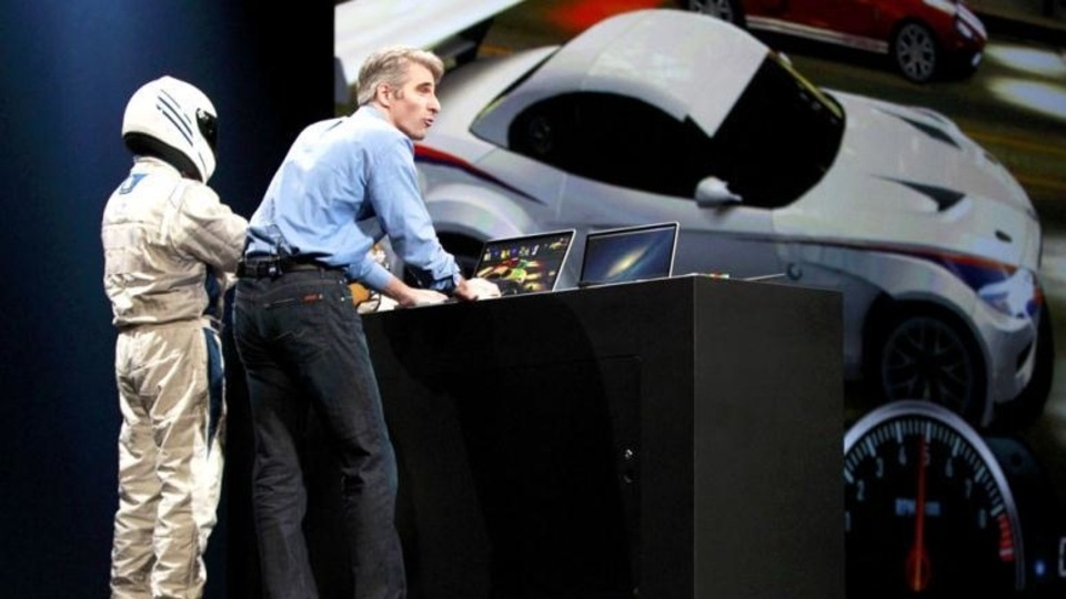 Craig Federighi, Apple Senior Vice President, Software Engineering, with a man in a racing suit, demonstrates Racer OS X during the Apple Worldwide Developers Conference 2012 in San Francisco, California June 11, 2012. REUTERS/Stephen Lam