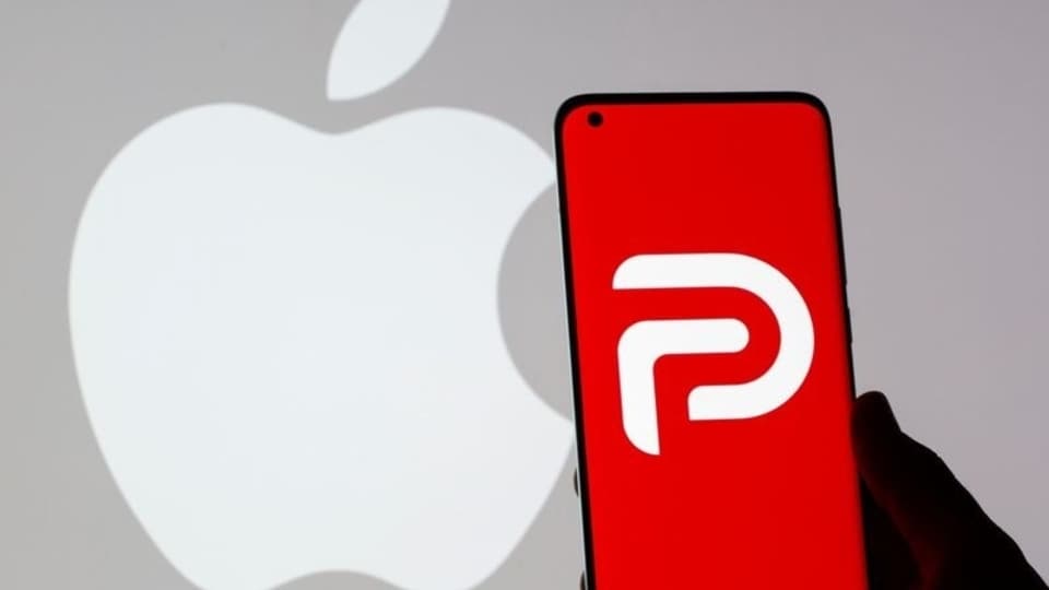 Woman holding smartphone with Parler logo in front of displayed Apple logo in this illustration taken May 17, 2021. REUTERS/Dado Ruvic