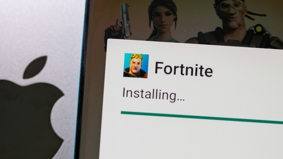 FILE PHOTO: Fortnite game installing on Android operating system is seen in front of Apple logo in this illustration taken, May 2, 2021.