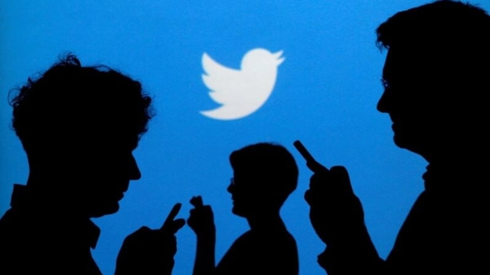 FILE PHOTO: People holding mobile phones are silhouetted against a backdrop projected with the Twitter logo in this illustration picture taken September 27, 2013. REUTERS/Kacper Pempel/Illustration/File Photo/File Photo