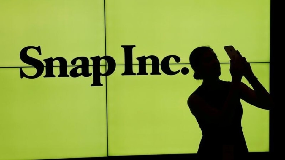 FILE PHOTO: A woman stands in front of the logo of Snap Inc on the floor of the New York Stock Exchange (NYSE) in New York City, NY, U.S. March 2, 2017. REUTERS/Lucas Jackson