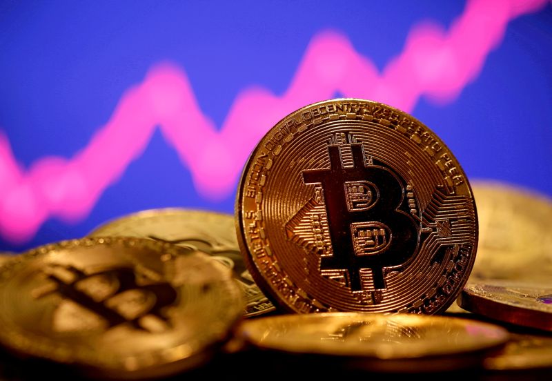 FILE PHOTO: A representation of virtual currency Bitcoin is seen in front of a stock graph in this illustration taken January 8, 2021. REUTERS/Dado Ruvic